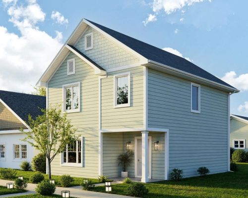 Light green two-story house with white trim at The Bend at Cramerton Mills, featuring a porch and landscaped yard on a sunny day.