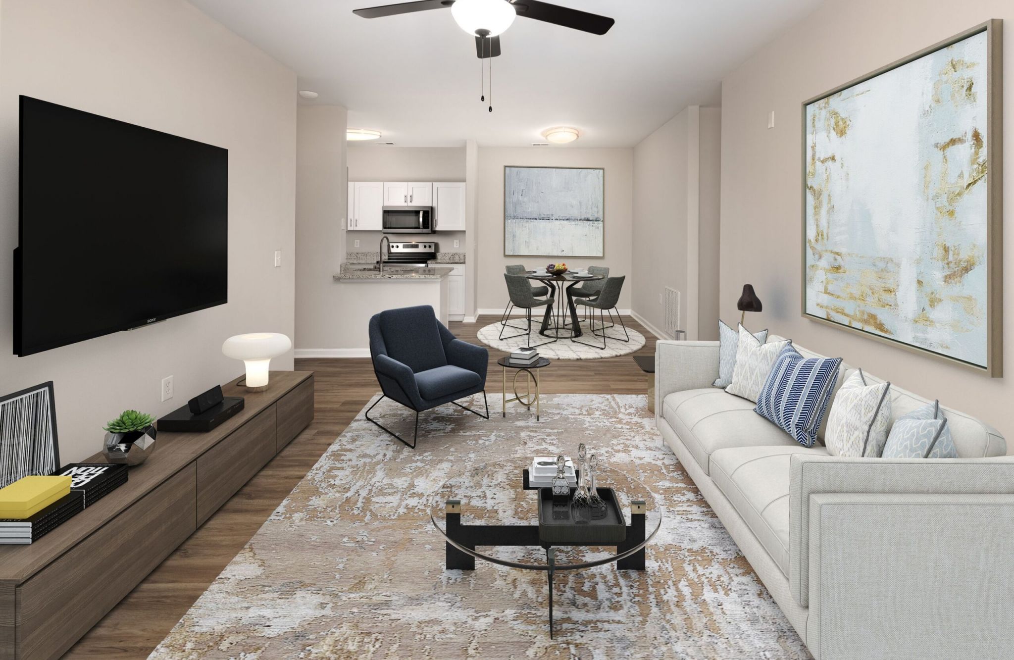 Modern living room with beige sofa, abstract art, flat-screen TV, and dining area in the background.