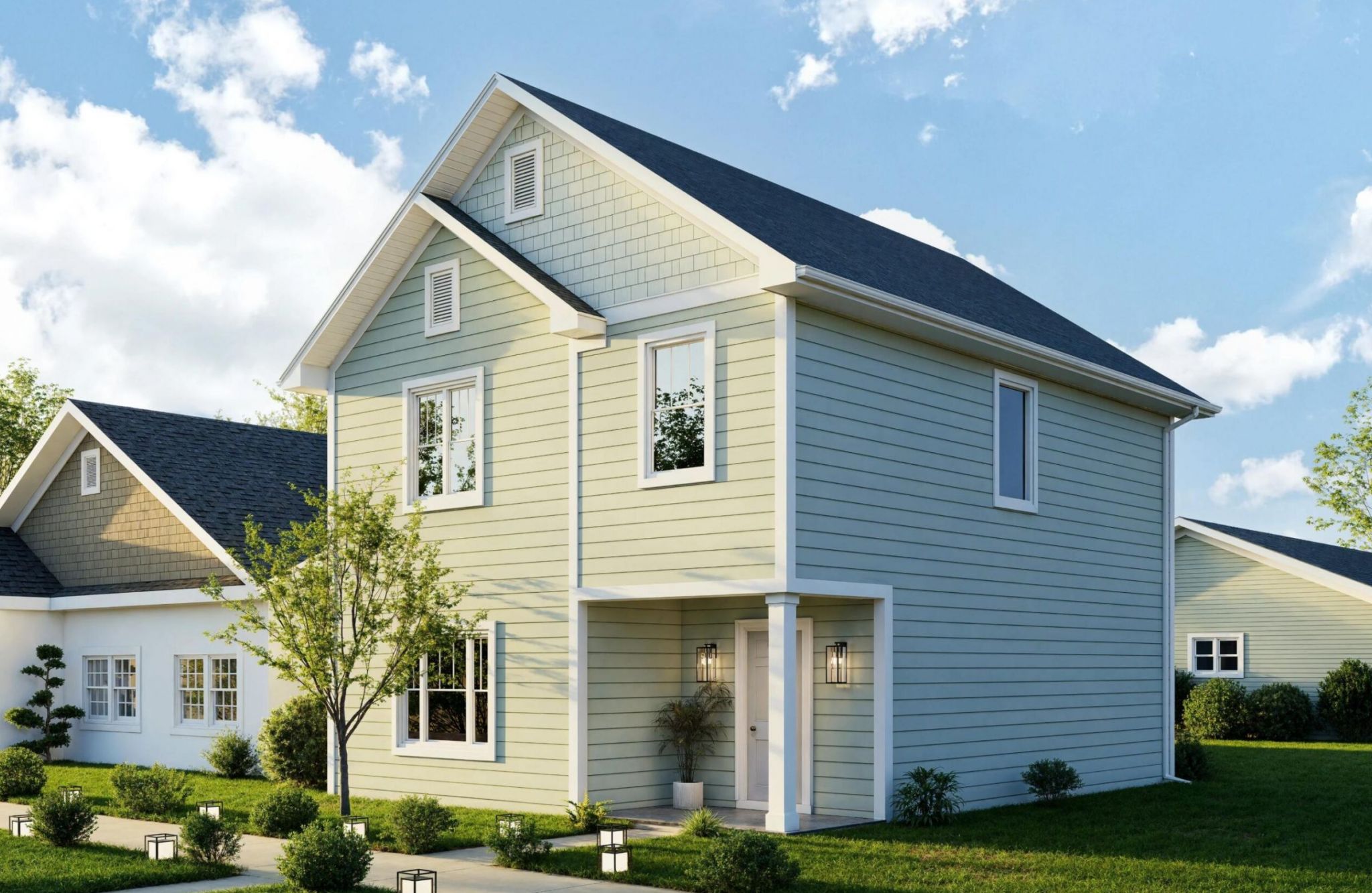 Light green two-story house with white trim at The Bend at Cramerton Mills, featuring a porch and landscaped yard on a sunny day.