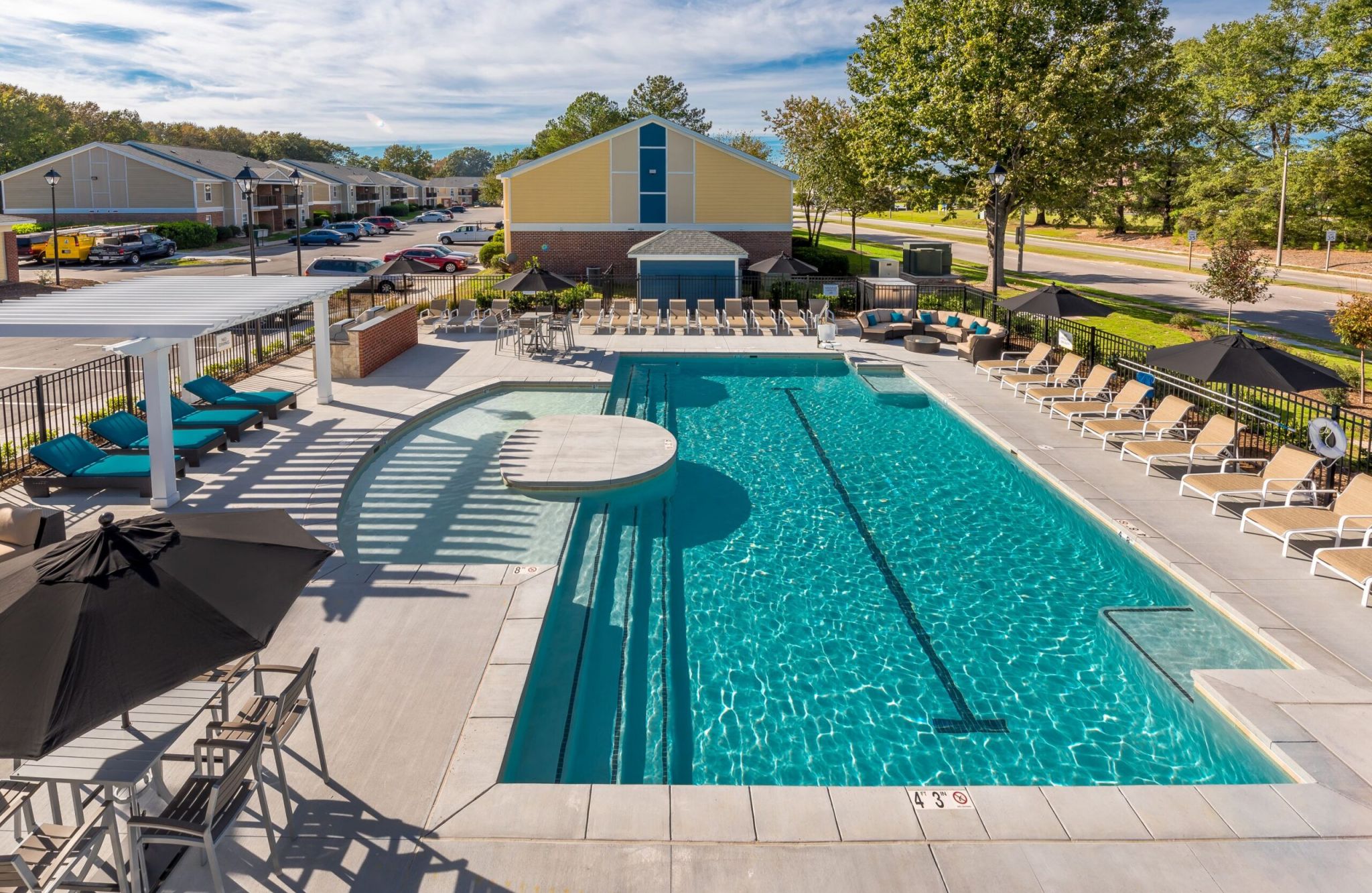 Amber at Greenbrier offers an outdoor pool area with lounge chairs, umbrellas, and a covered seating section for perfect sunny days.