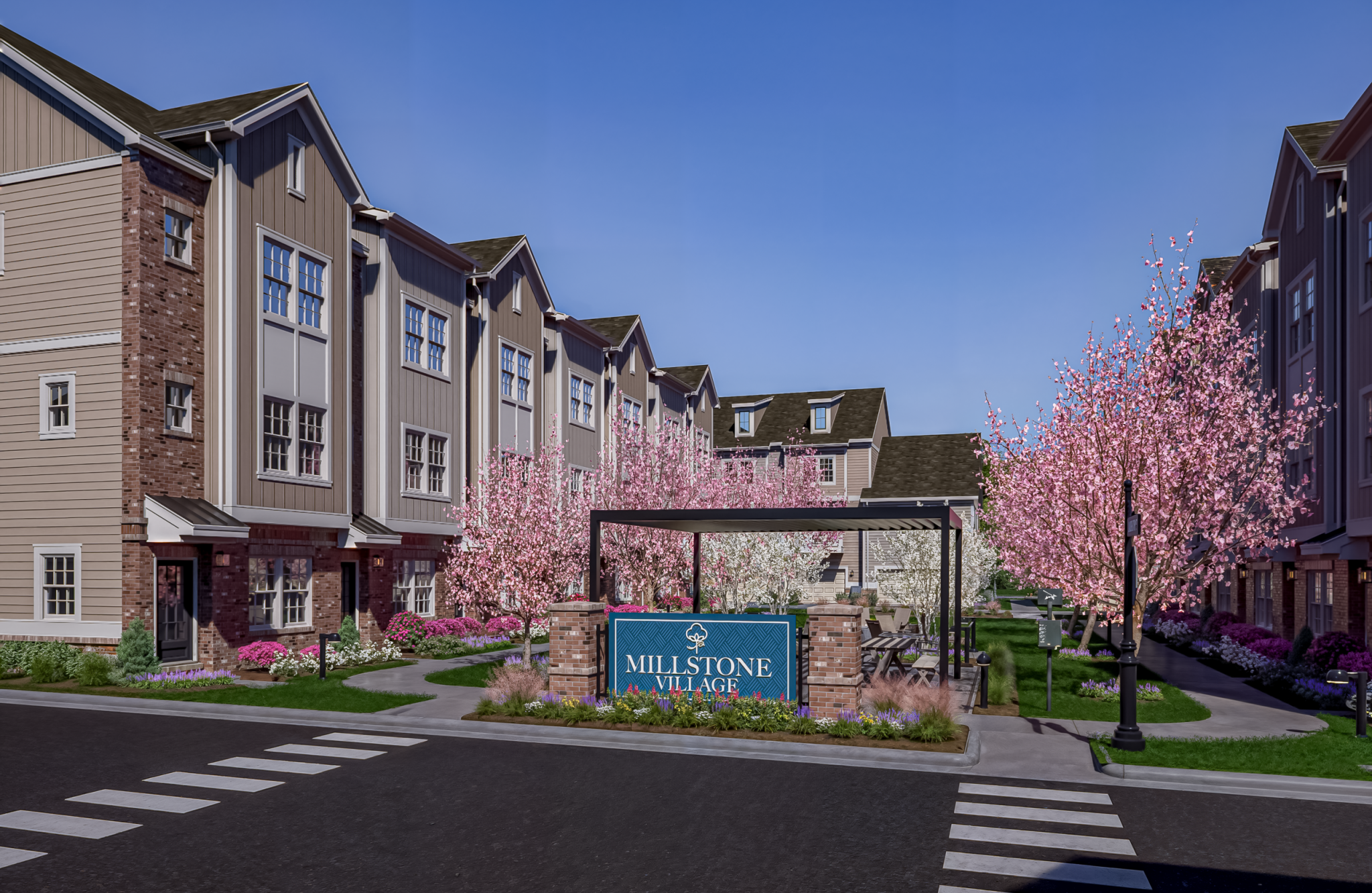The entrance sign to the Townes at Millstone apartment complex, surrounded by blooming cherry blossom trees.